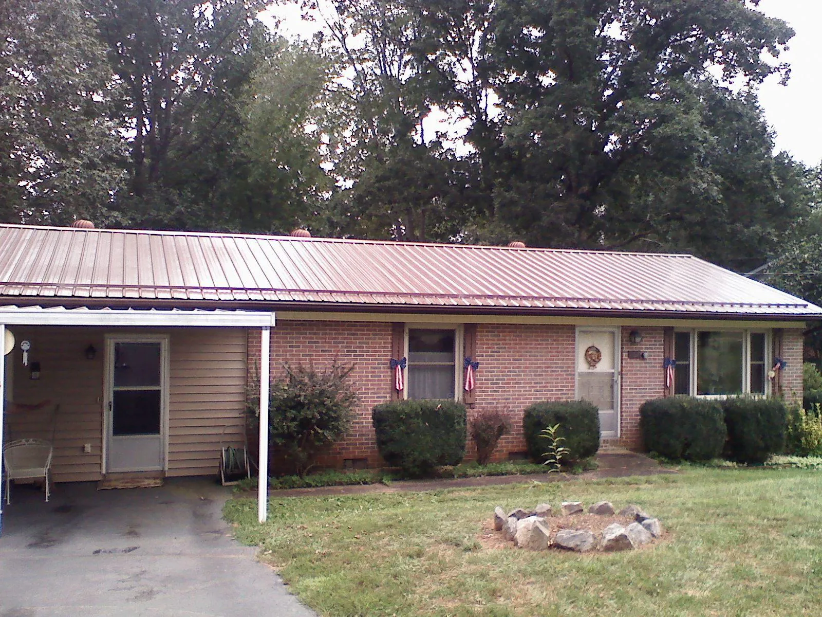 Bronze metal roof and carport on a brick ranch home — Roof Repair work by our crew in Dunn